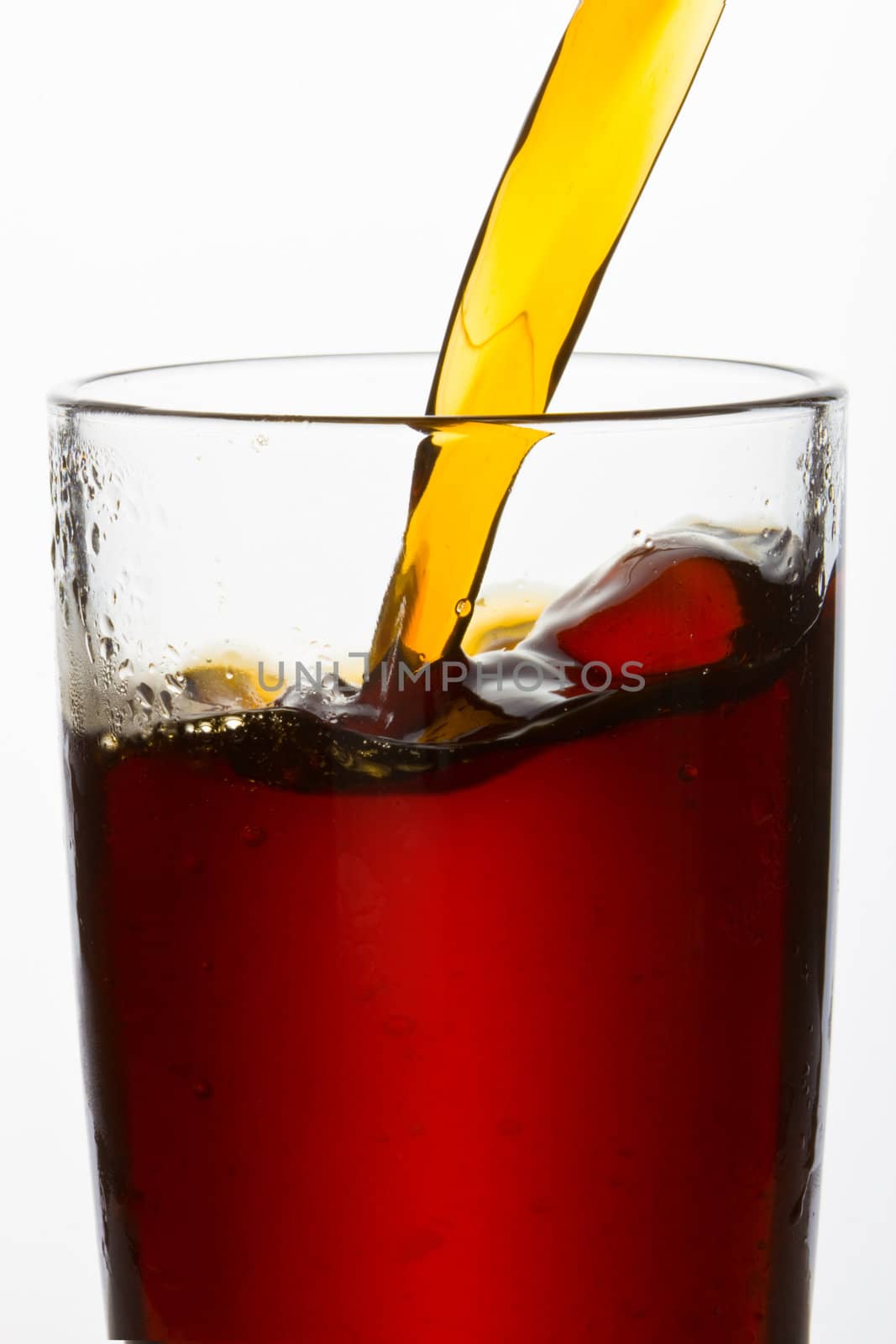 drink poured into a glass over white background