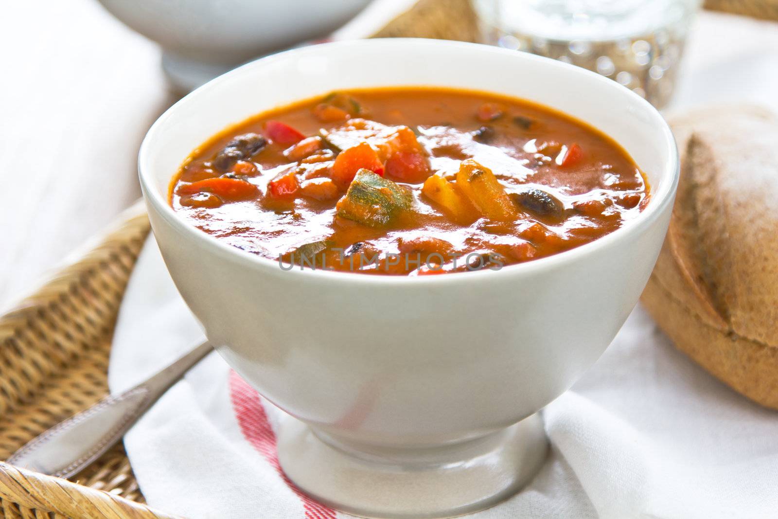 Minestrone soup [Zucchini,aubergine,bean,pepper and carrot in tomato soup ] by a loaf of bread