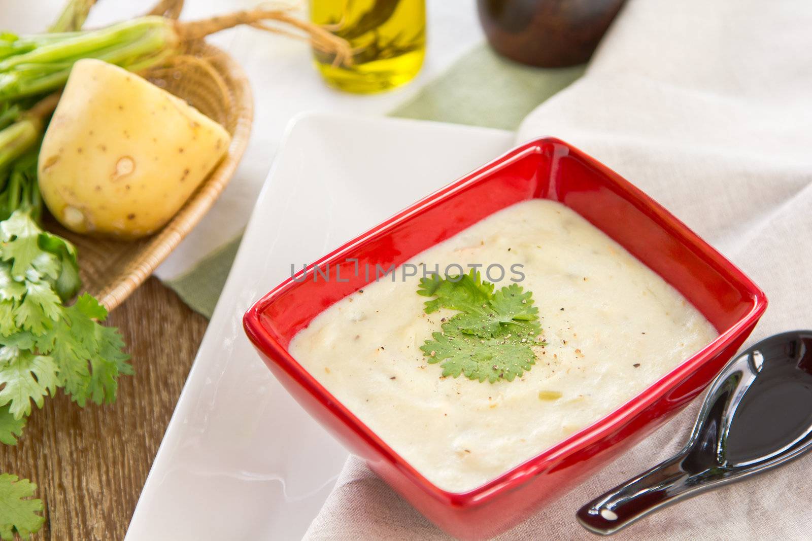 Potato soup with coriander by some potatoes and bunch of coriander