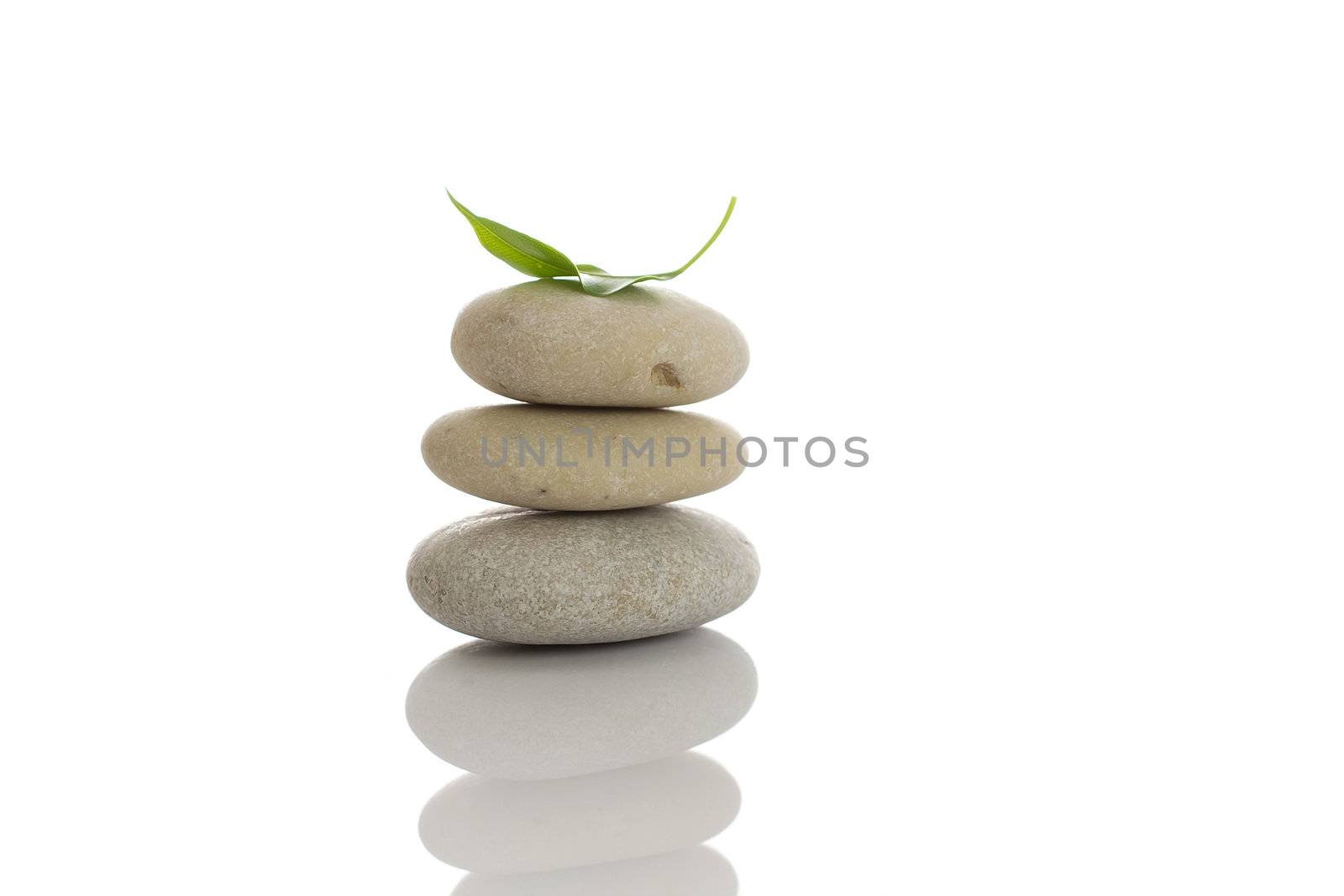 Spa stones and green leaf, isolated on white background.