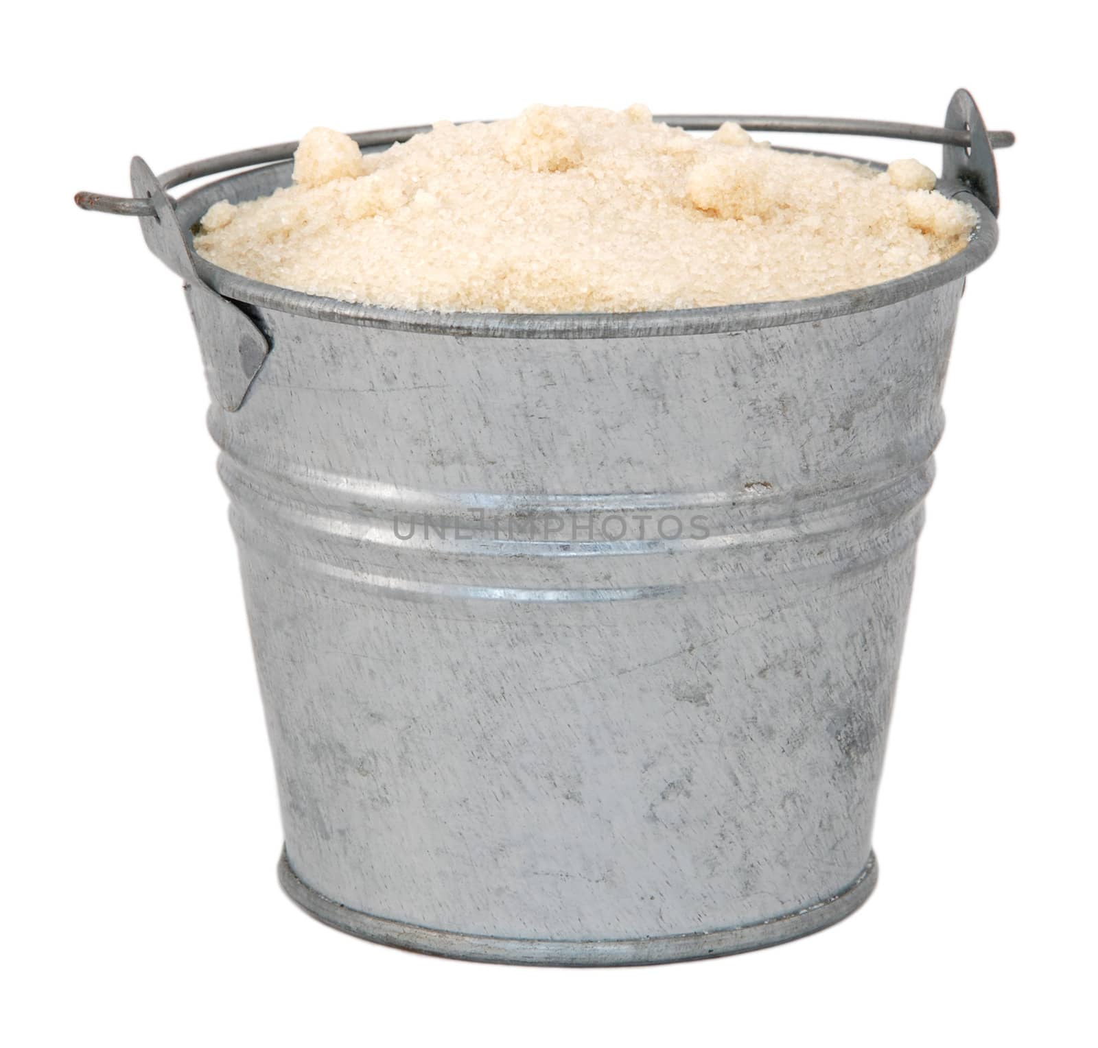 Golden caster sugar in a miniature metal bucket, isolated on a white background