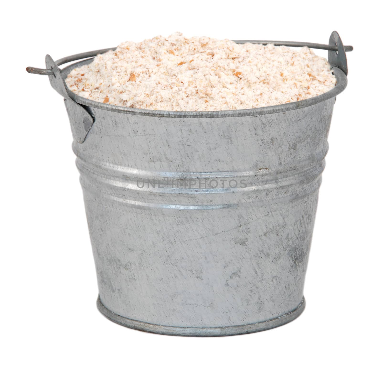 Wholemeal / wheatmeal / brown flour in a miniature metal bucket, isolated on a white background