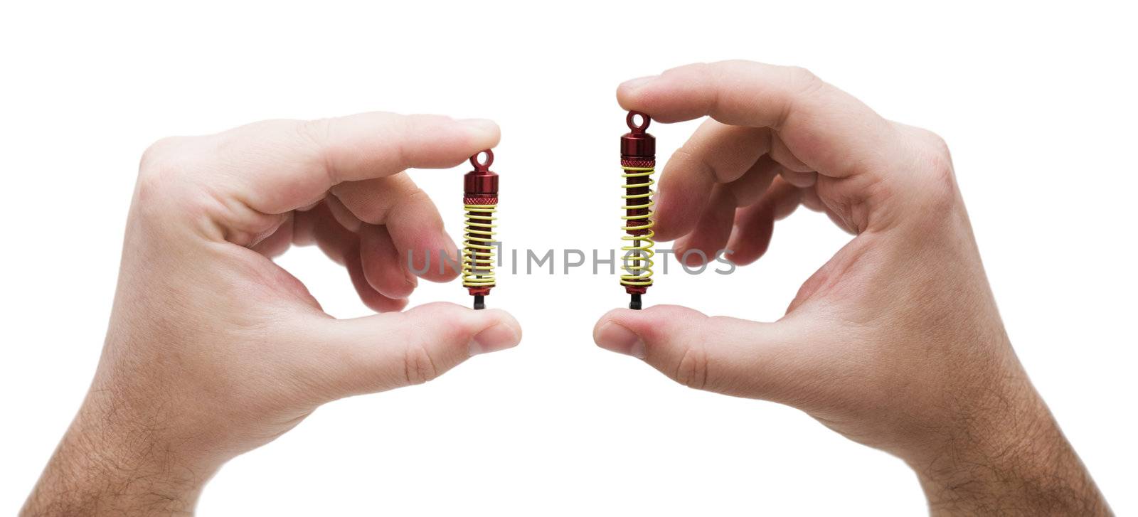 shock absorbers from the toy car in hands on white background