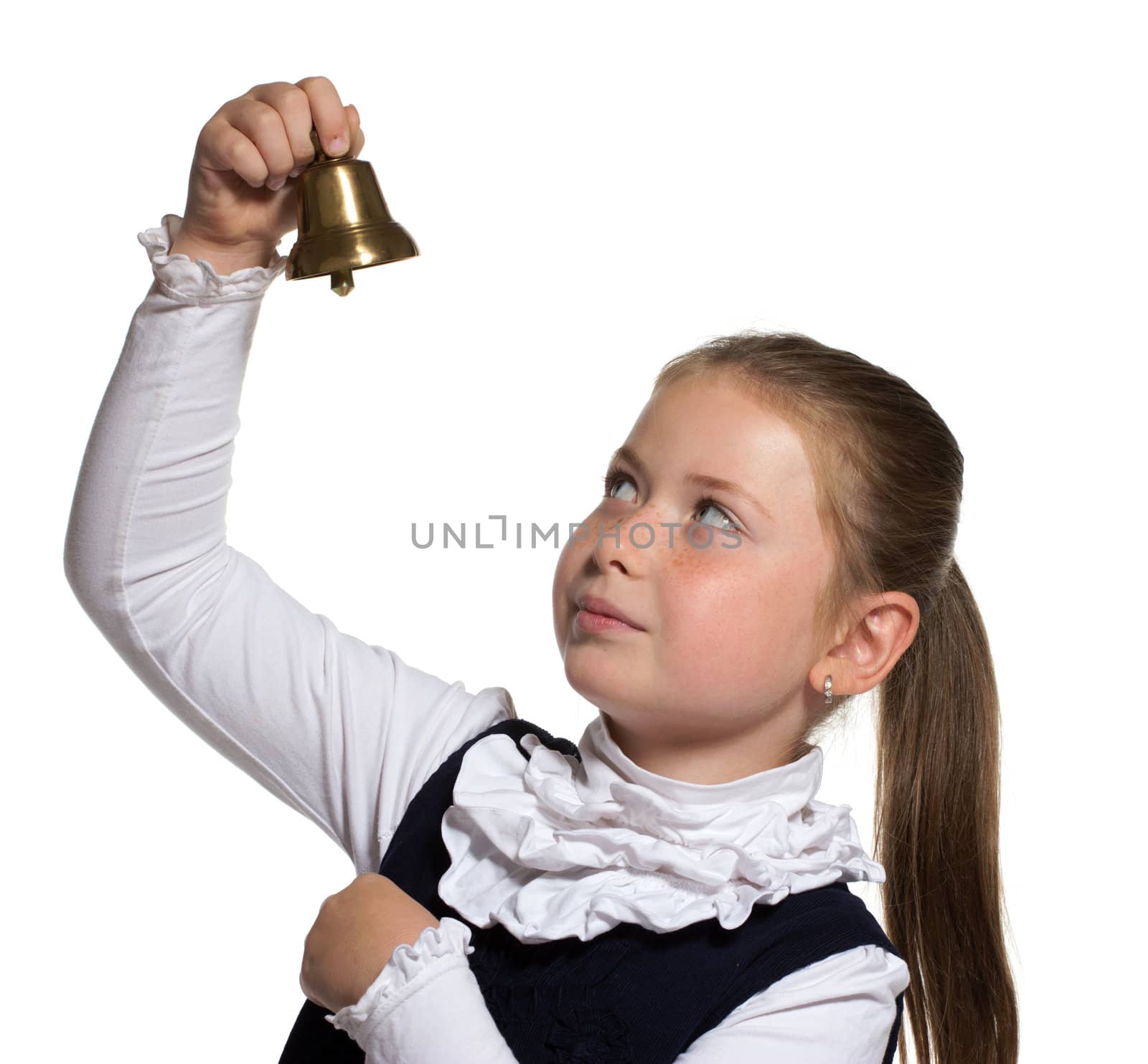 Young school girl looking to golden bell on white background