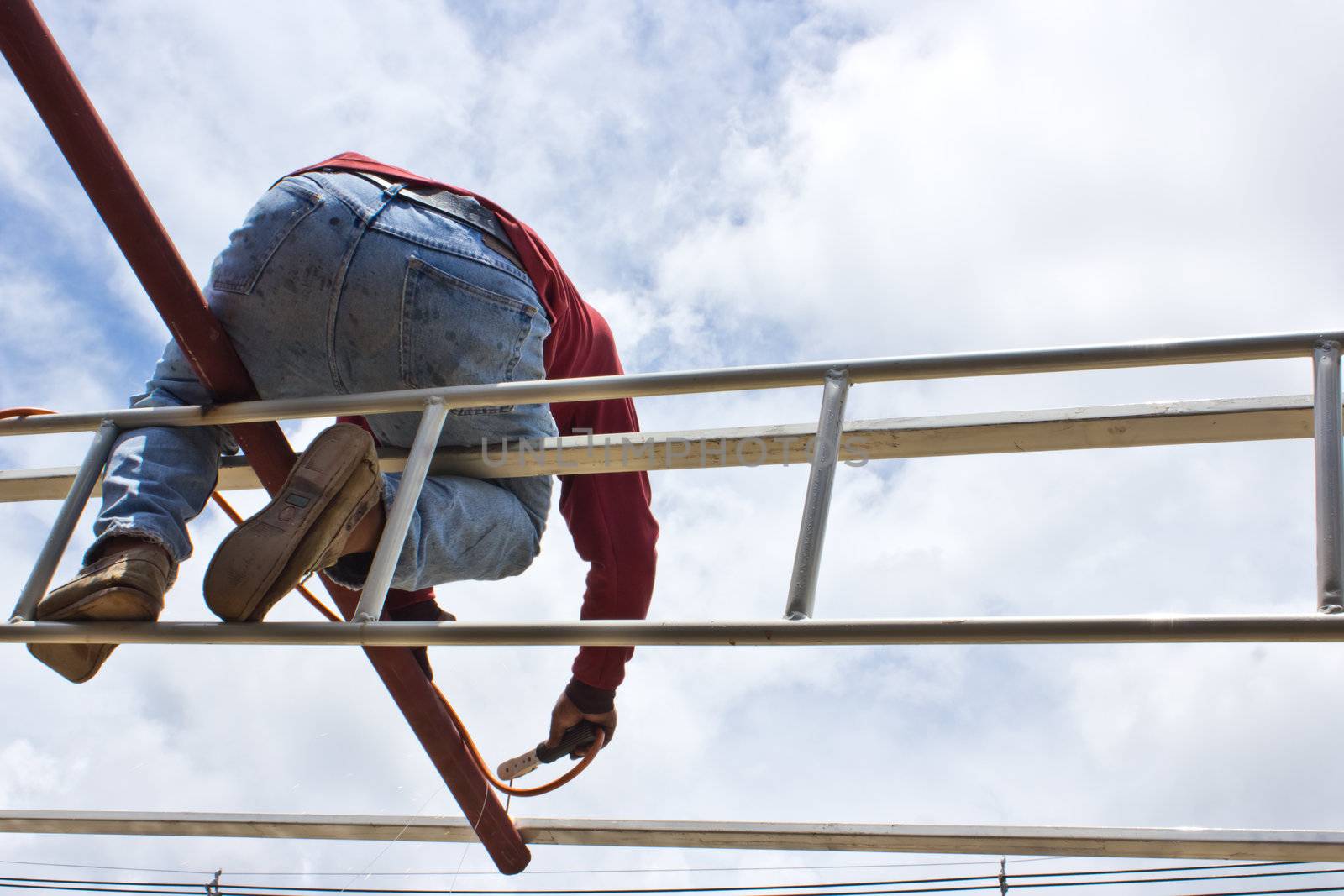 a roofer on a roof putting down shingles