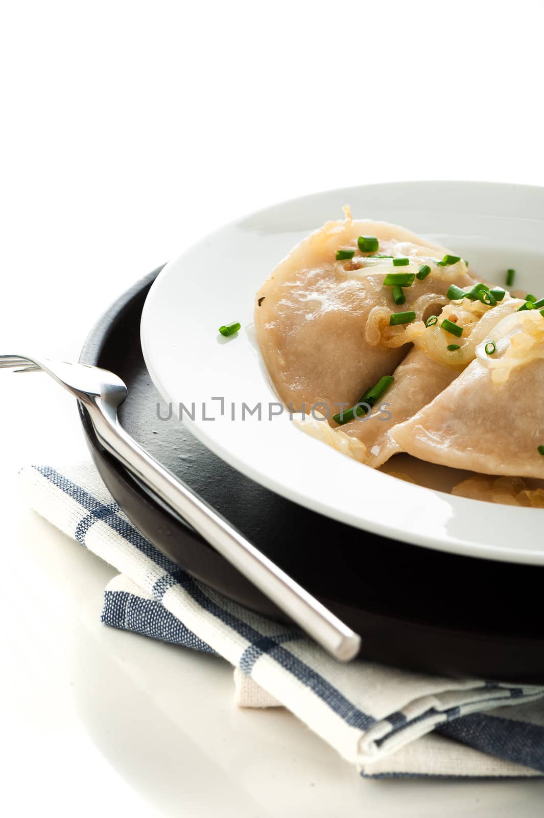 Homemade pierogi or dumpling on white and black plate