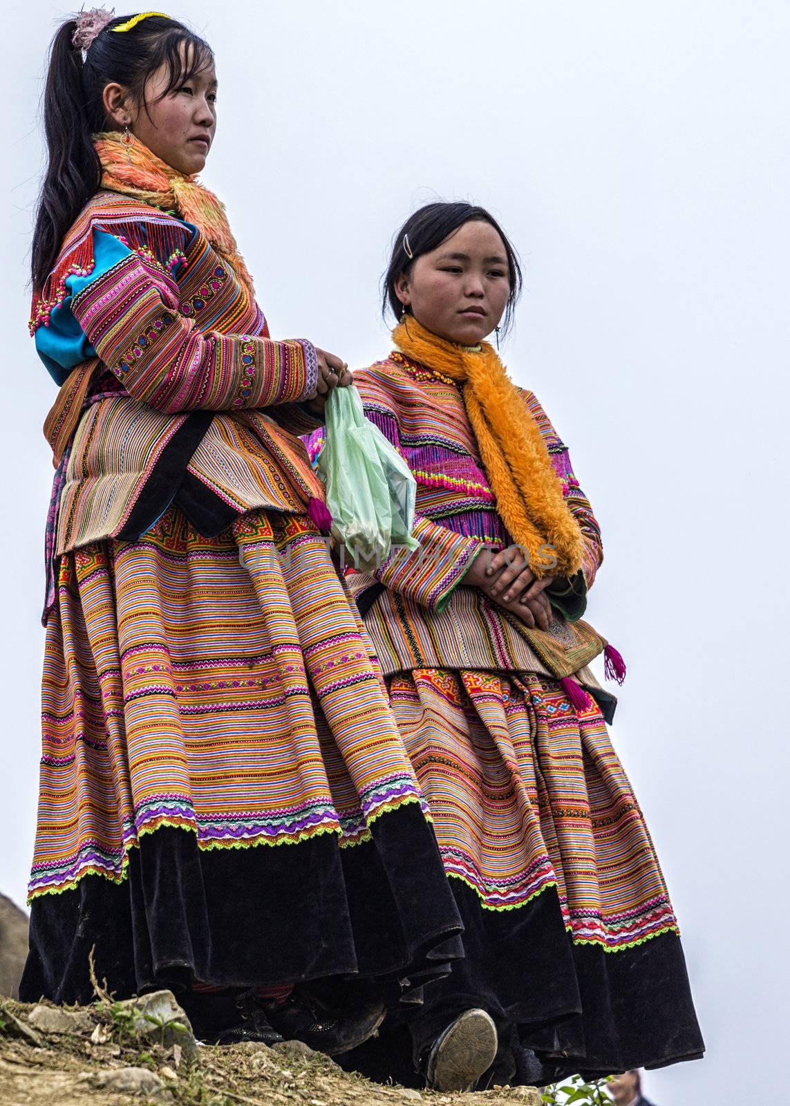 Vietnam Bac Ha - March 2012: Two young Hmong sisters show and wa by Claudine