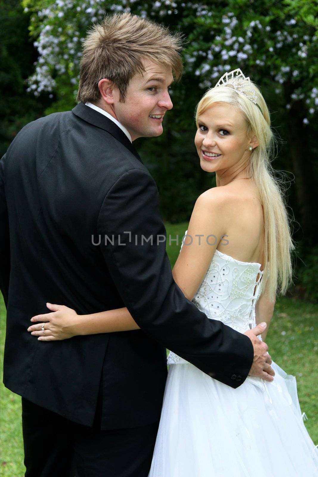 Lovely young wedding couple looking back and smiling