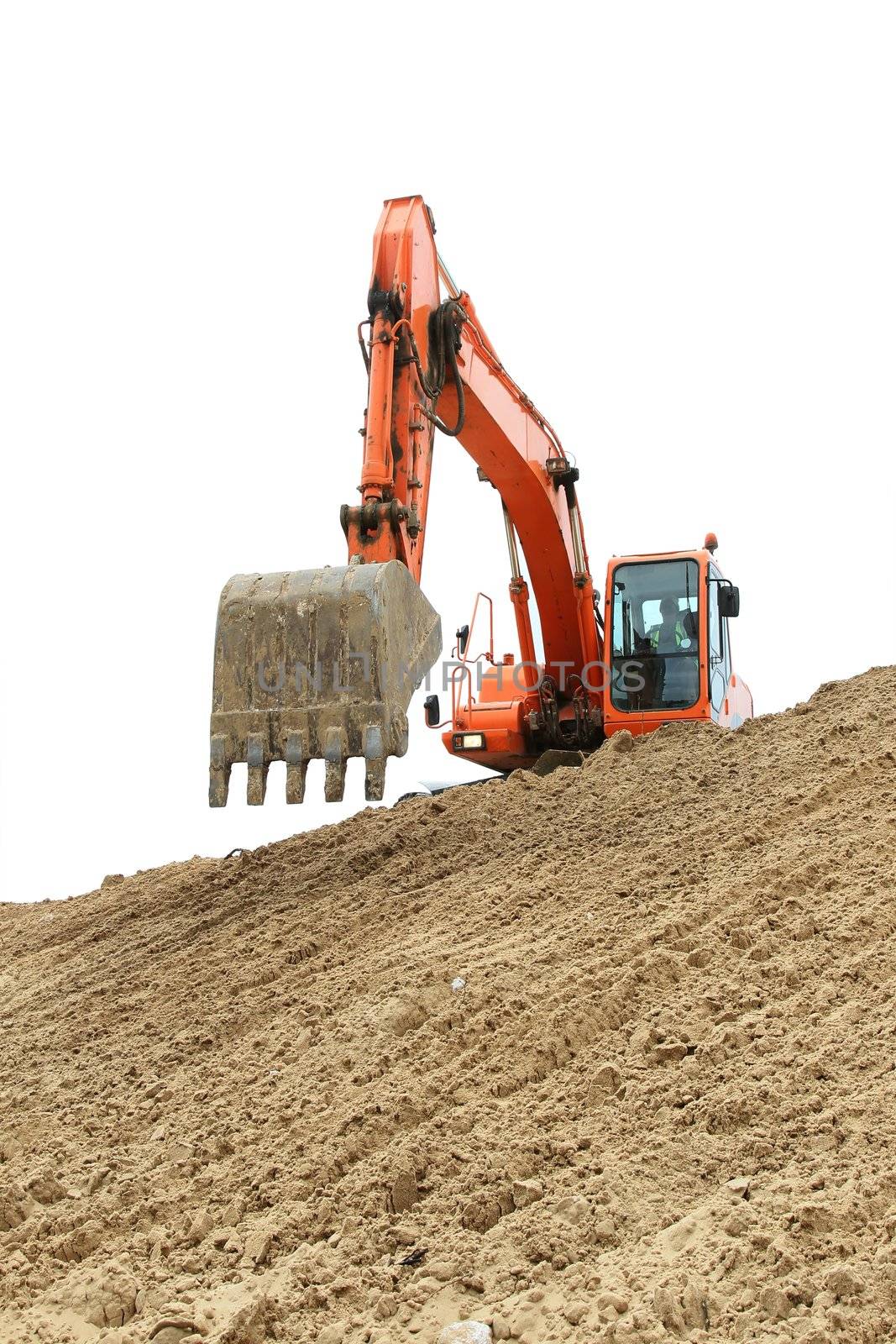 Orange digging machine excavation in a sandy pit