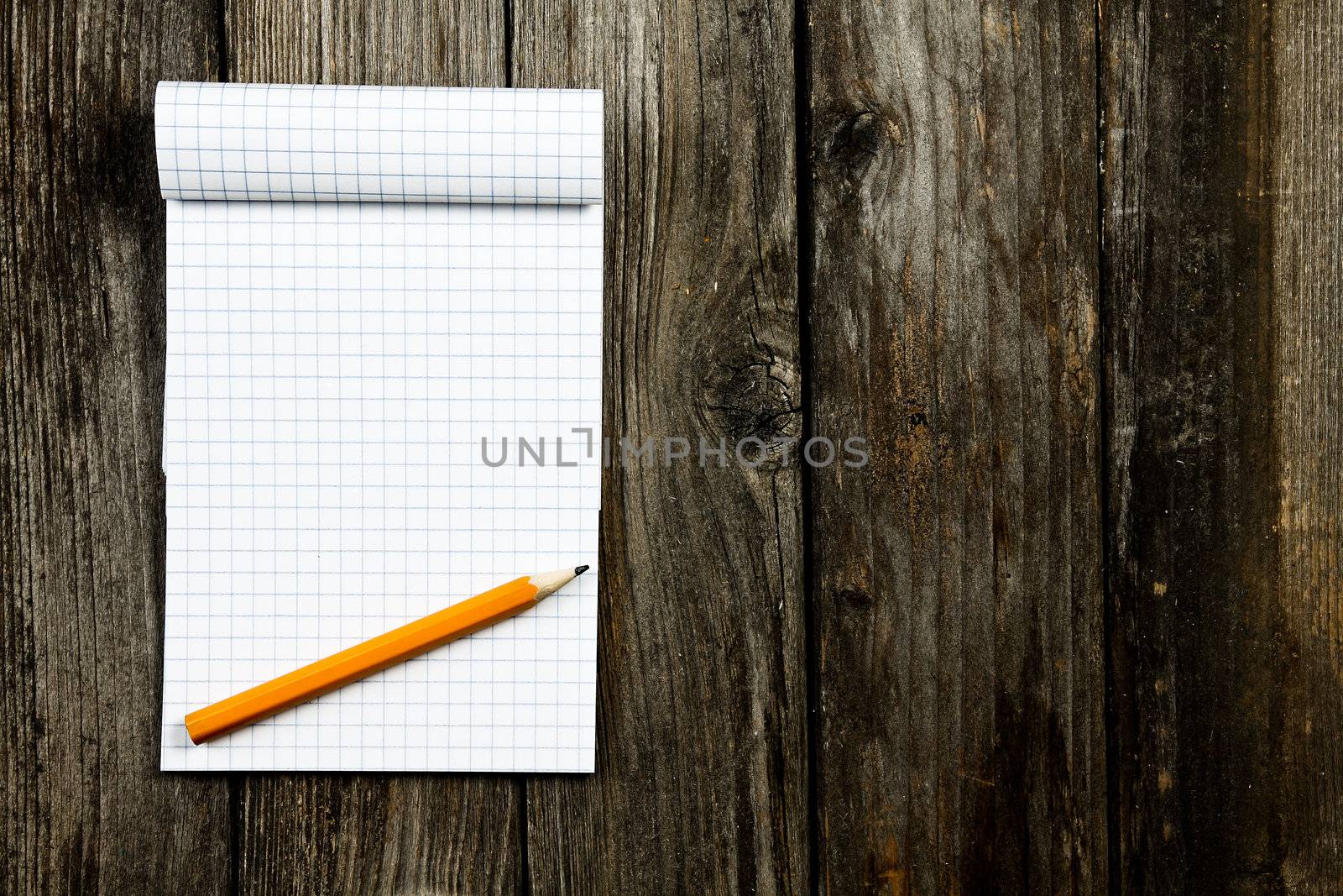 notepad and pencil on a wooden planks