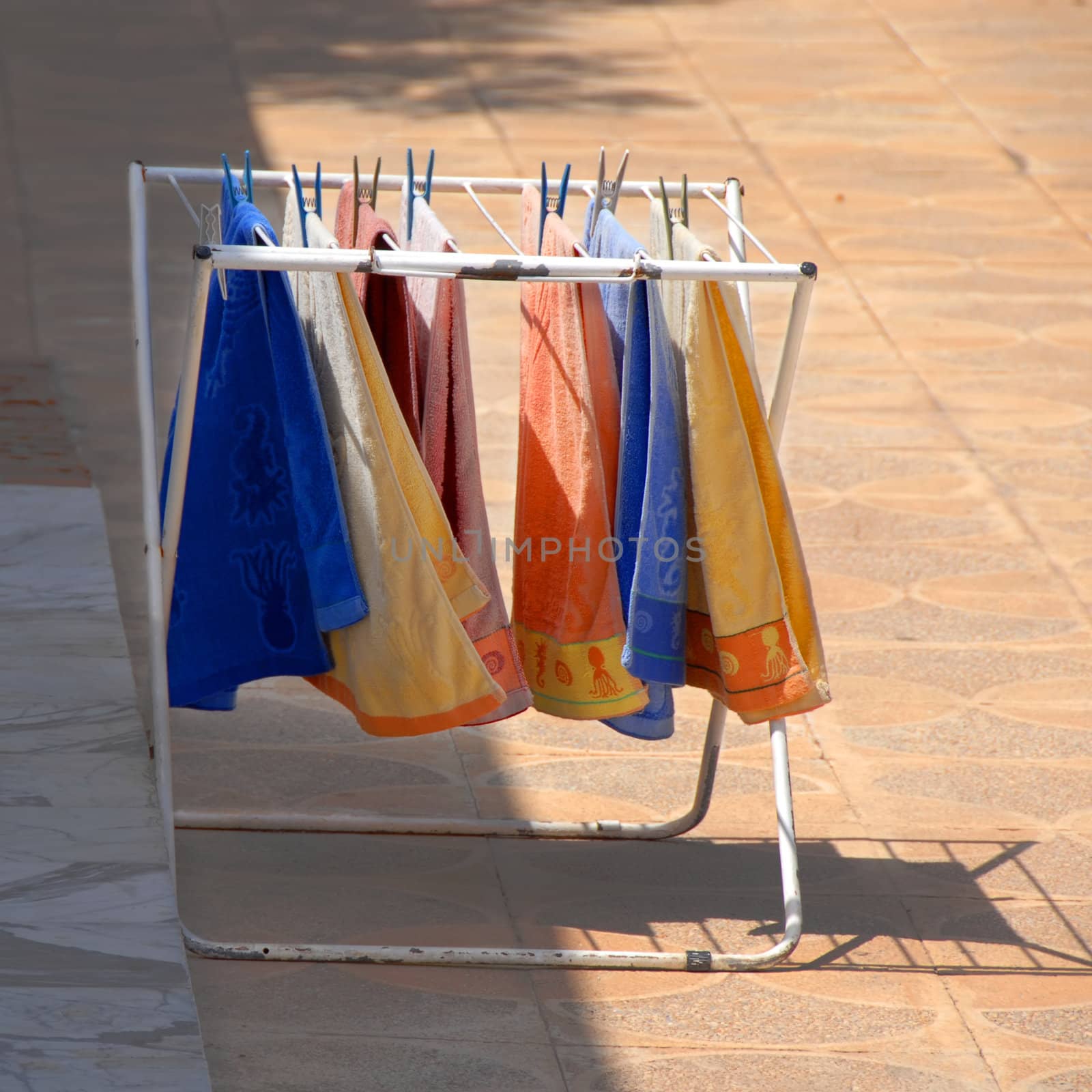 various colorful towels hanging on dryer at sunny day