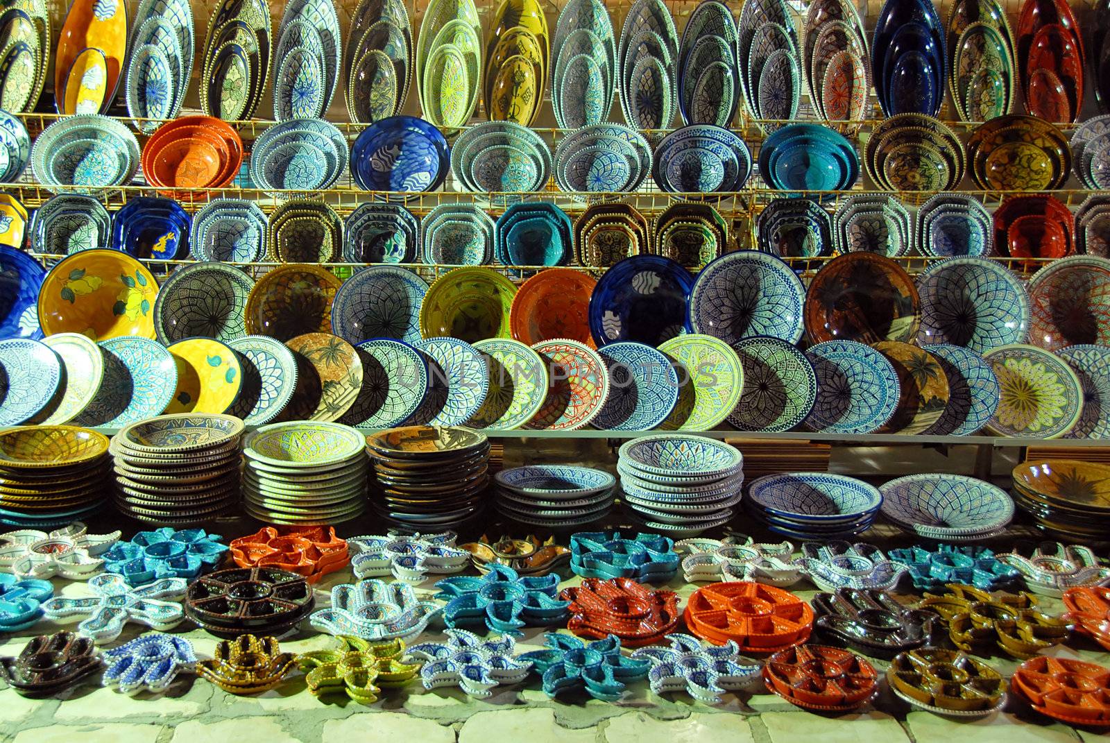 various pottery on shelves of oriental outdoor store in Tunisia at the evening