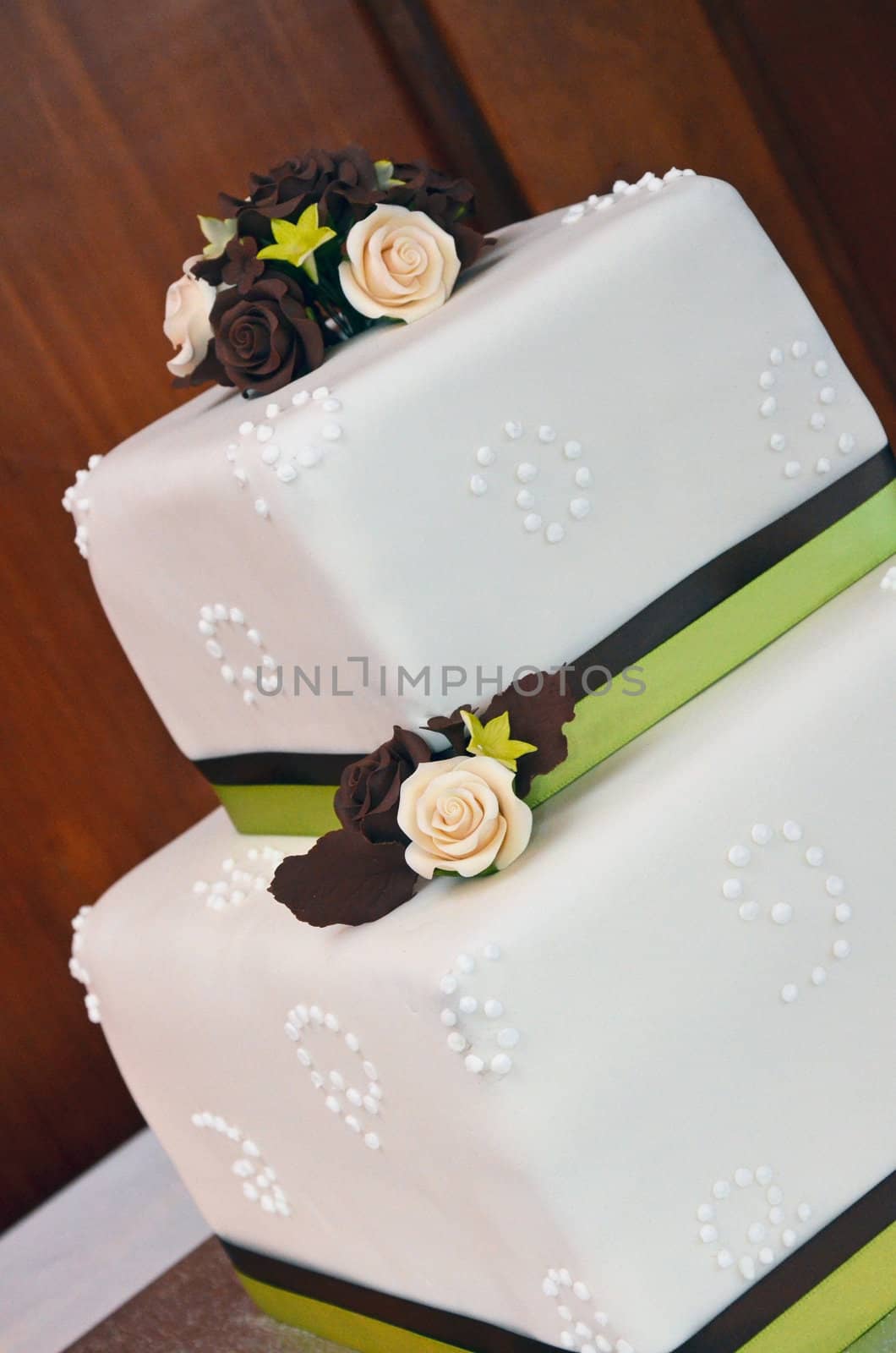 White fondant wedding cake with brown and pink roses