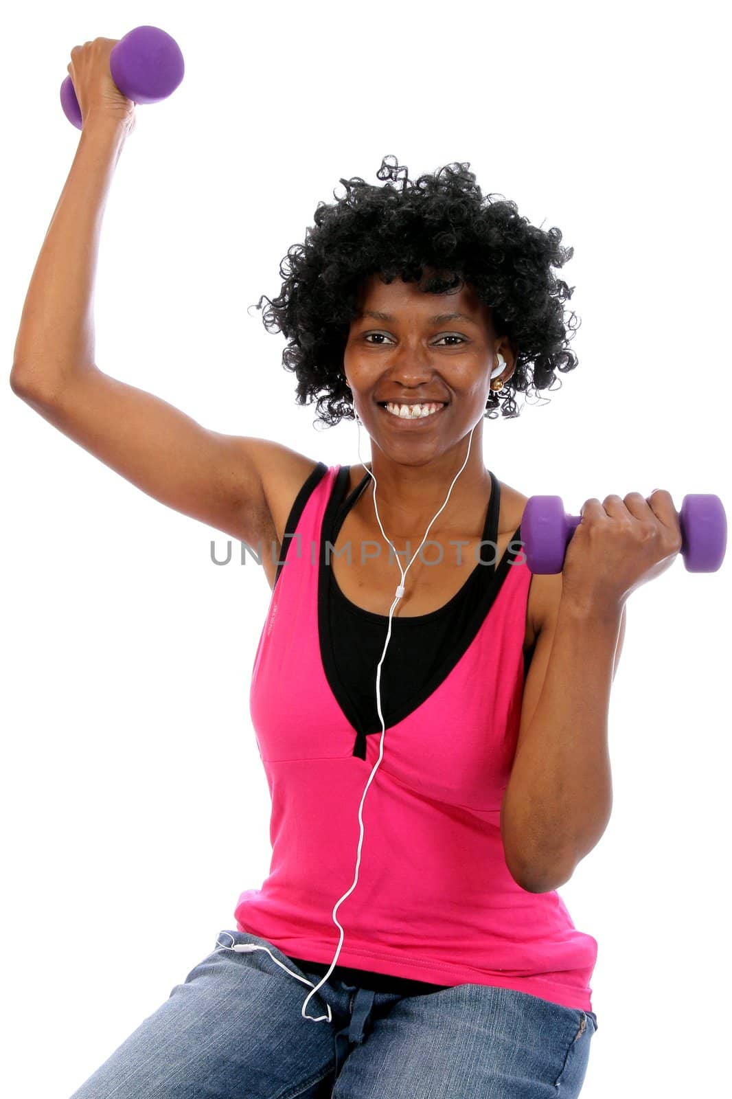 Happy African woman working out with gym weights and listening to music on earphones