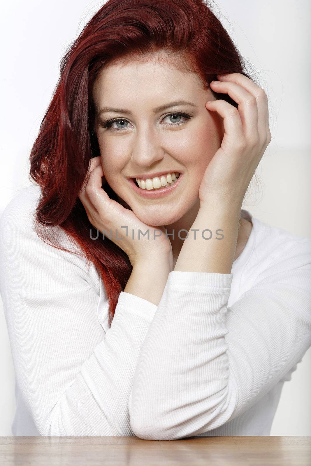 Beautiful young woman resting on a coffee table in front of sofa at home.