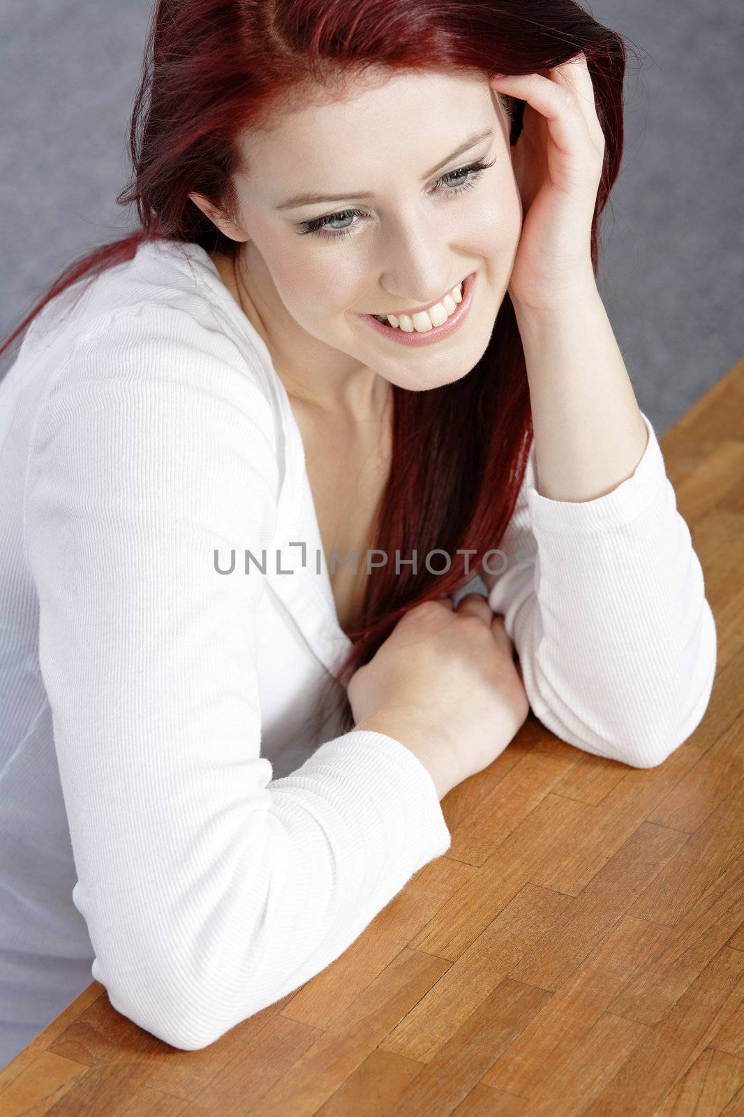 Beautiful young woman resting on a coffee table in front of sofa at home.