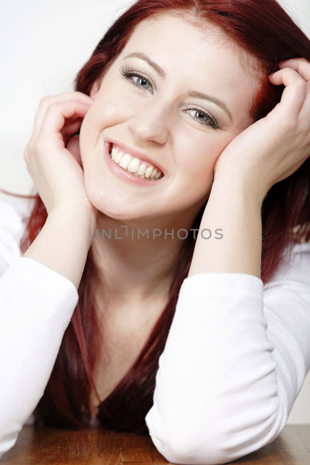 Beautiful young woman resting on a coffee table in front of sofa at home.