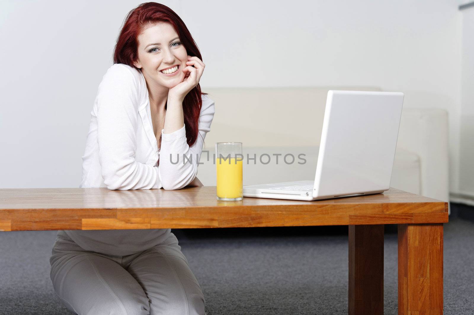 Happy smiling woman at home on laptop by studiofi