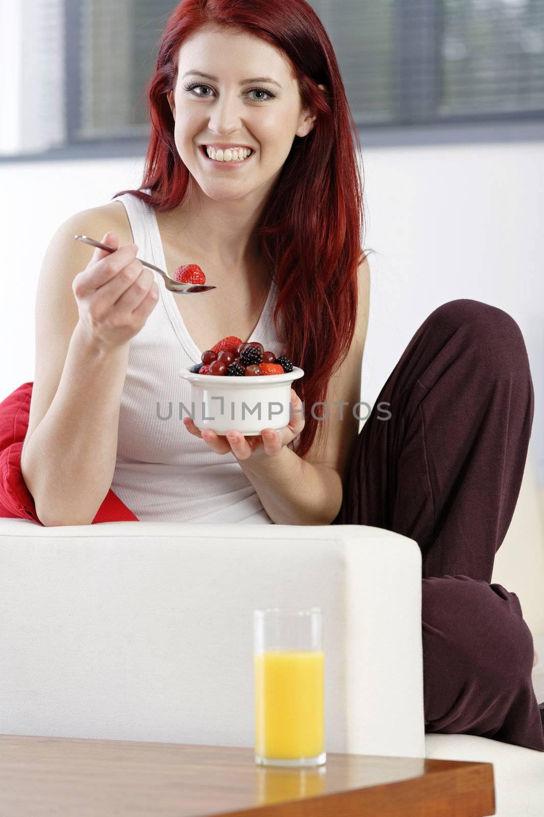 Happy woman eating breakfast by studiofi