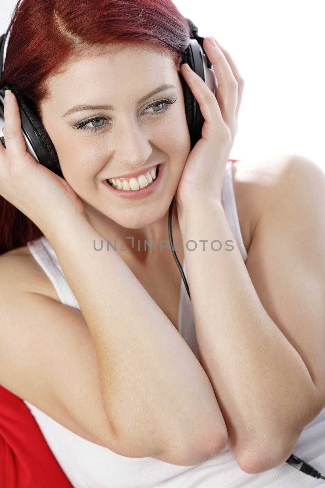 Happy young woman listening to music by studiofi