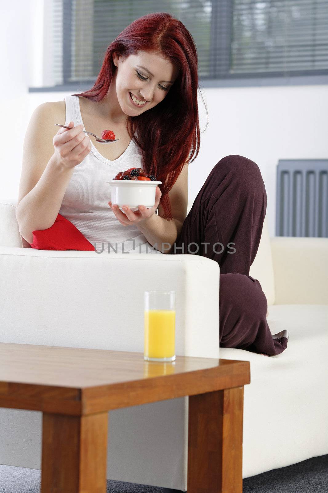 Happy woman eating breakfast by studiofi