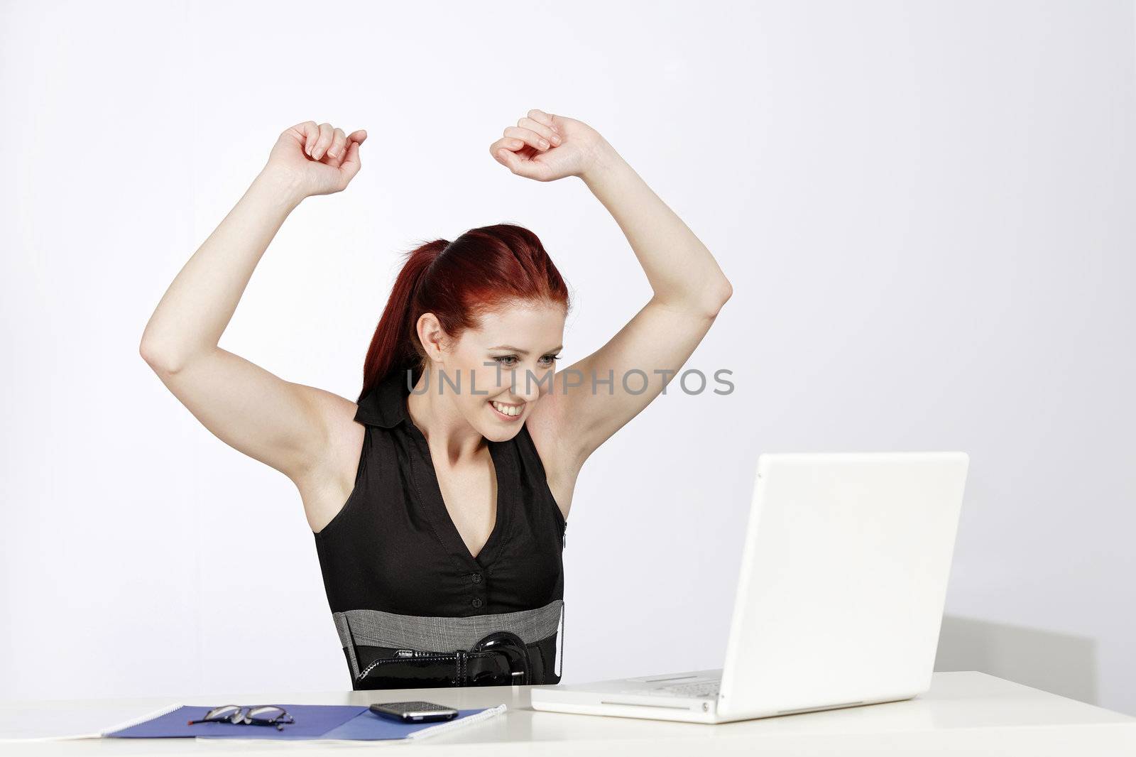 Professional young woman celebrating at work in her office