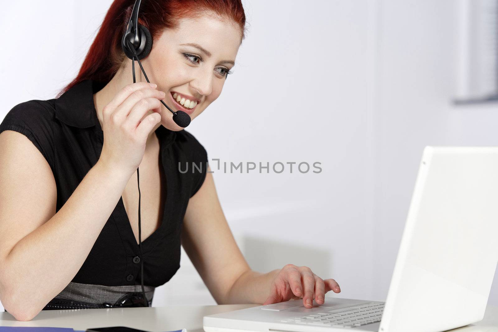 Professional woman talking on a headset in her office at work