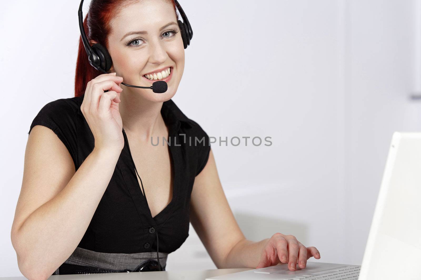 Professional woman talking on a headset in her office at work