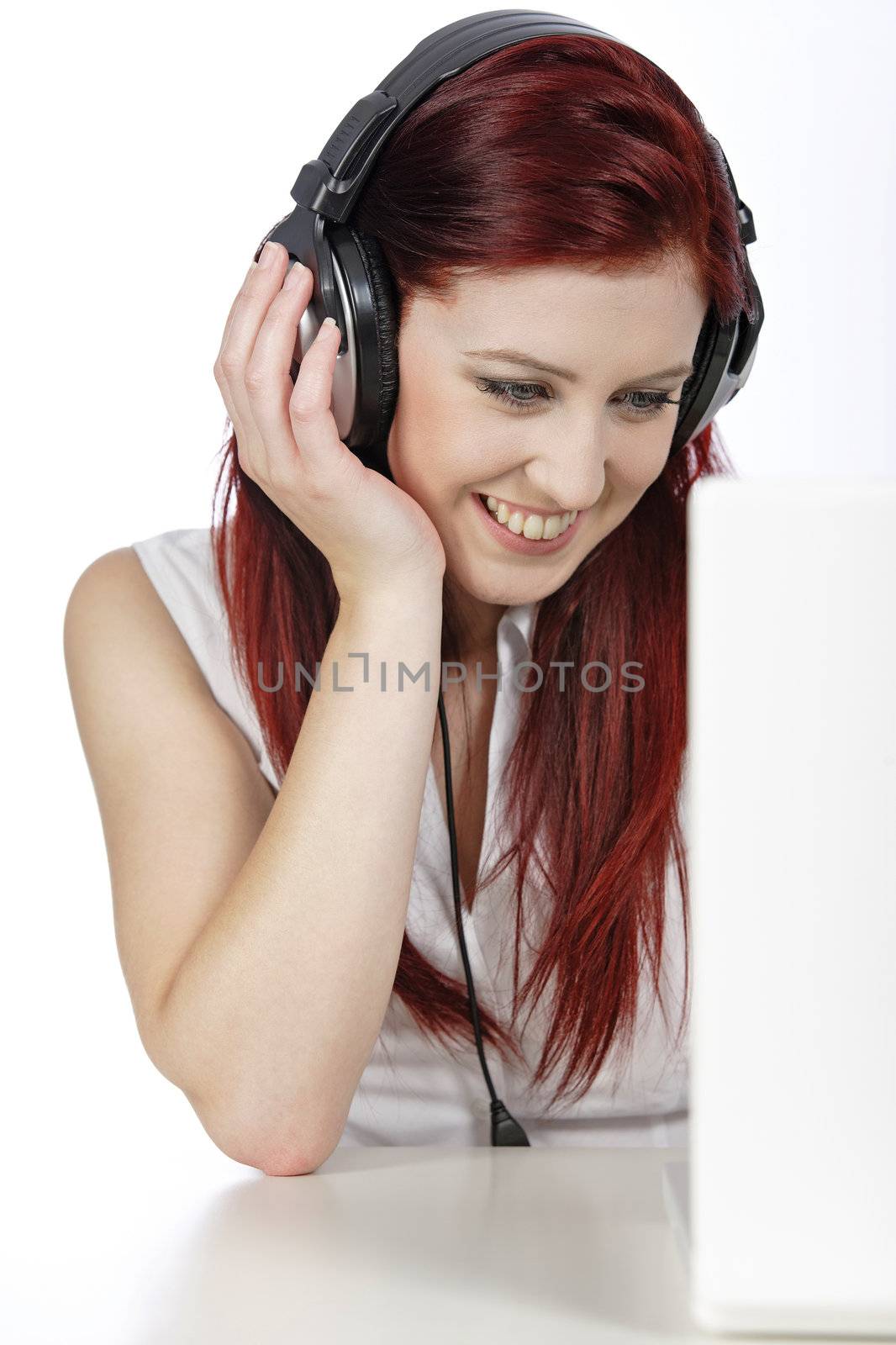 Beautiful woman working on laptop listening to music on her heaphones