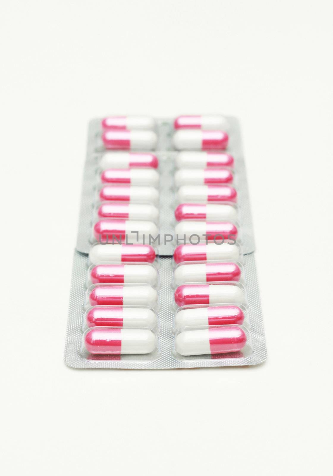 Capsules and pills packed in blisters isolated on white.