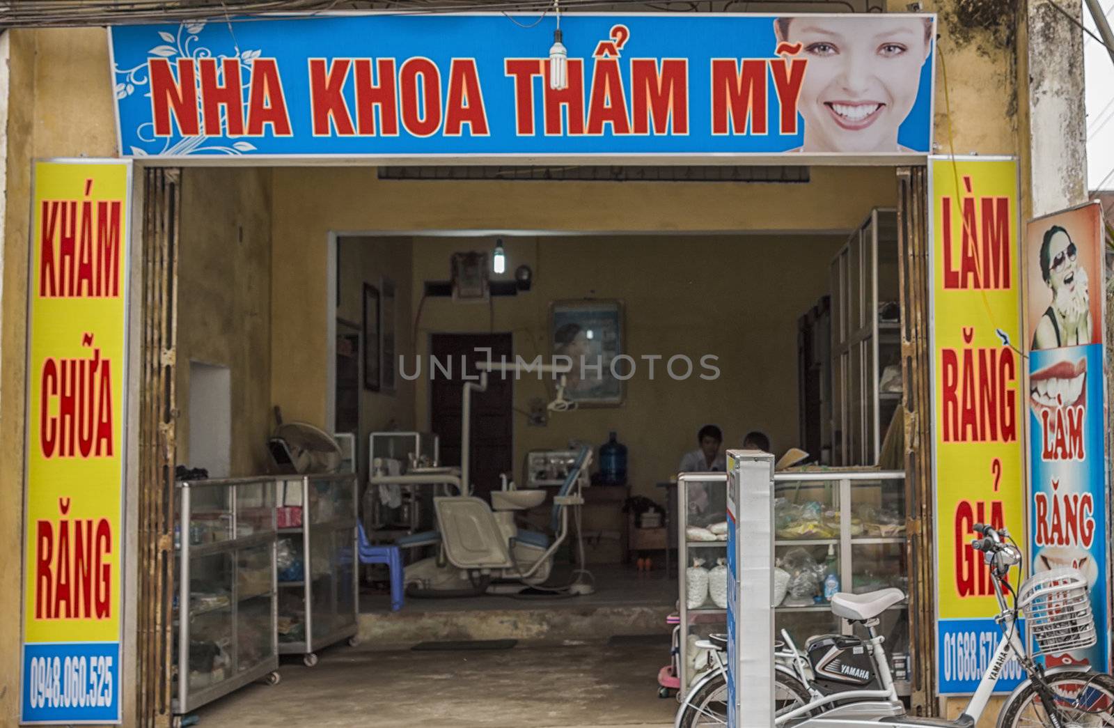 Front of office framed in advertisement posters looks into dental workplace.