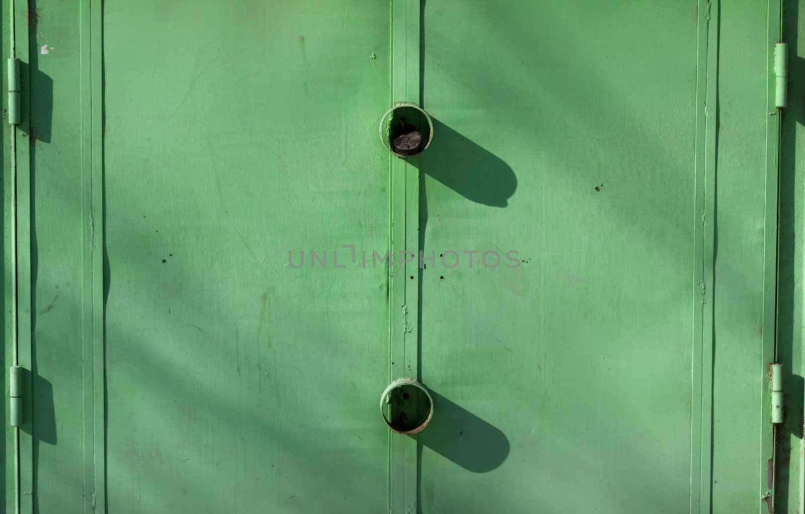 Old garage gates painted green with a padlock  by schankz