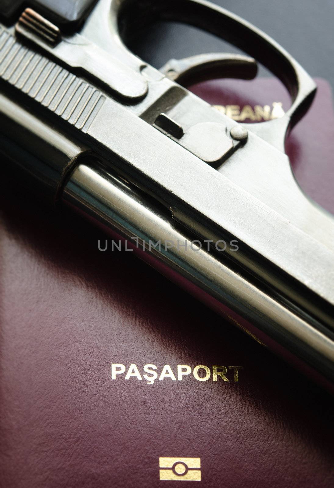 Close up of a passport and a used gun.Crime oversease