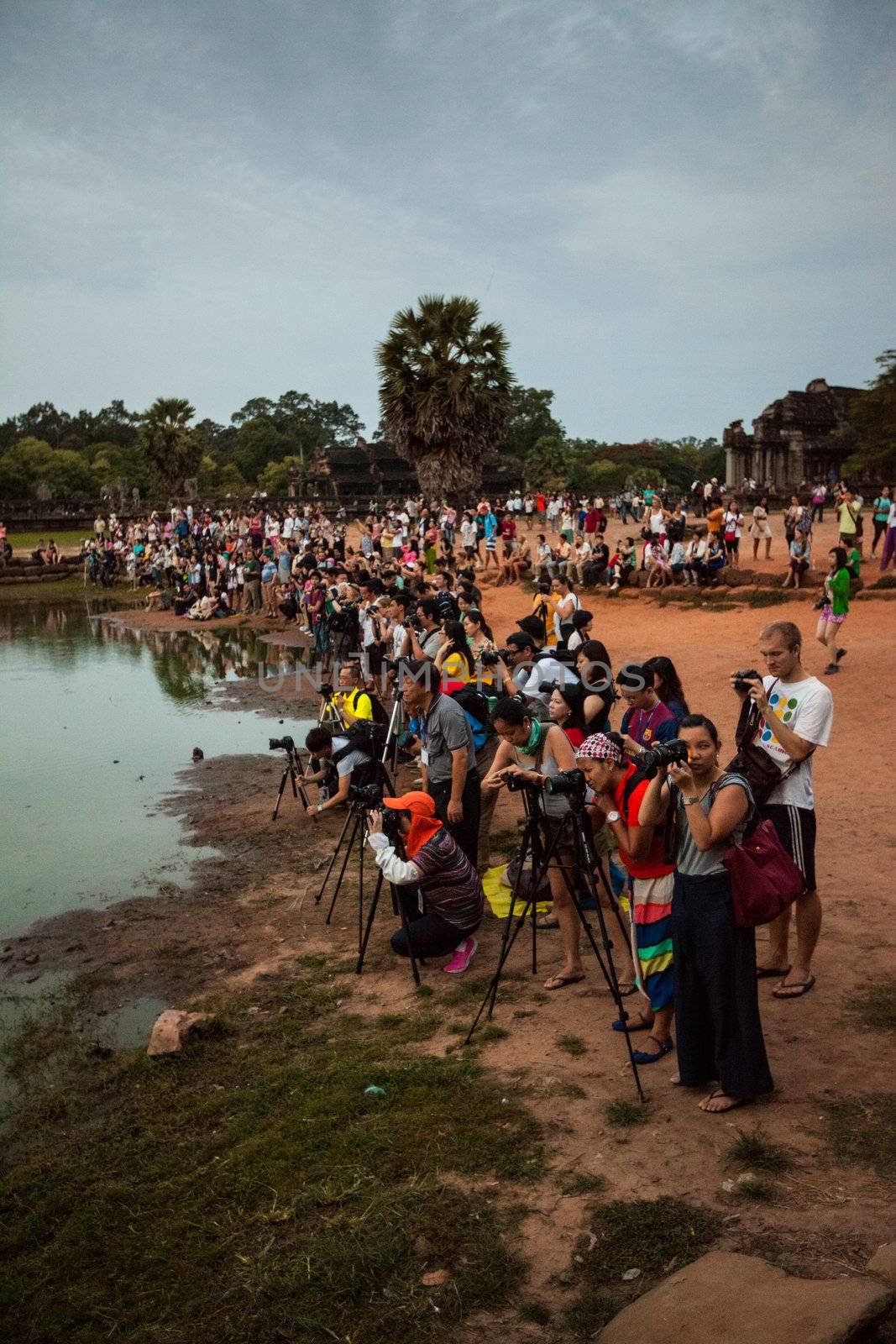 SIEM REAP, CAMBODIA - CIRCA JUNE 2012: unidentified photographers setting up their equipments at sunrise in front of the reflection pool/pond at Angkor Wat circa June 2012 in SIEM REAP, CAMBODIA. Low season from April to October see lower number of tourist at Angkor.