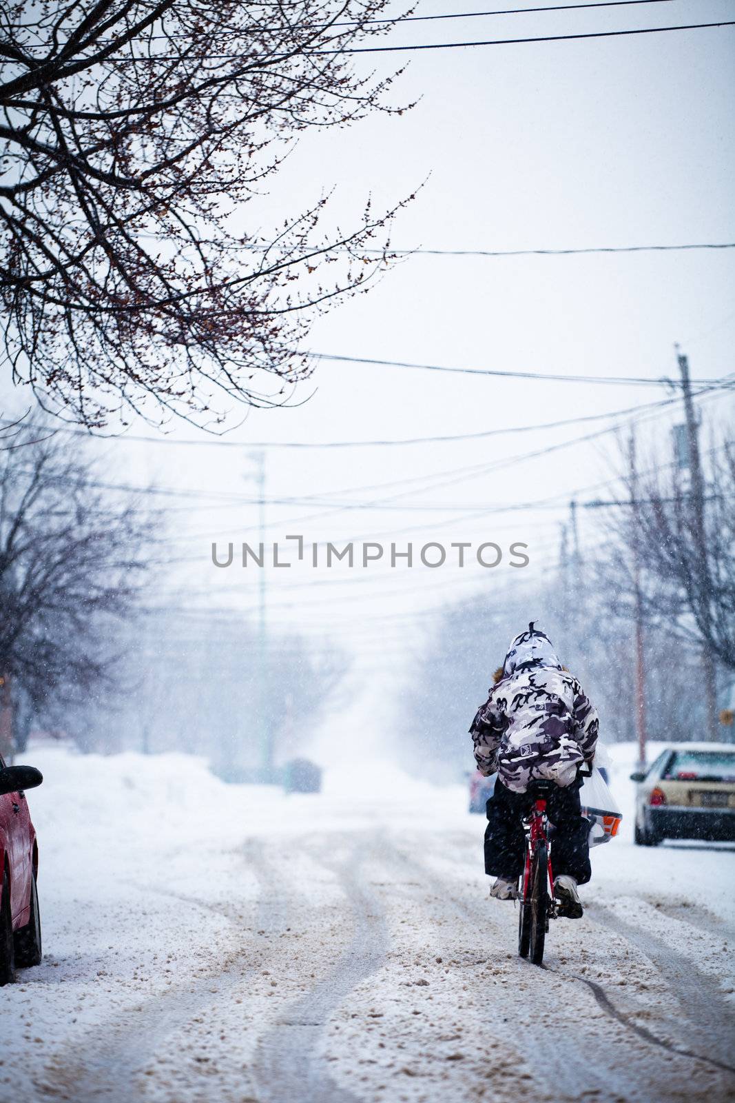 Courageous biker during a winter storm - editorial
