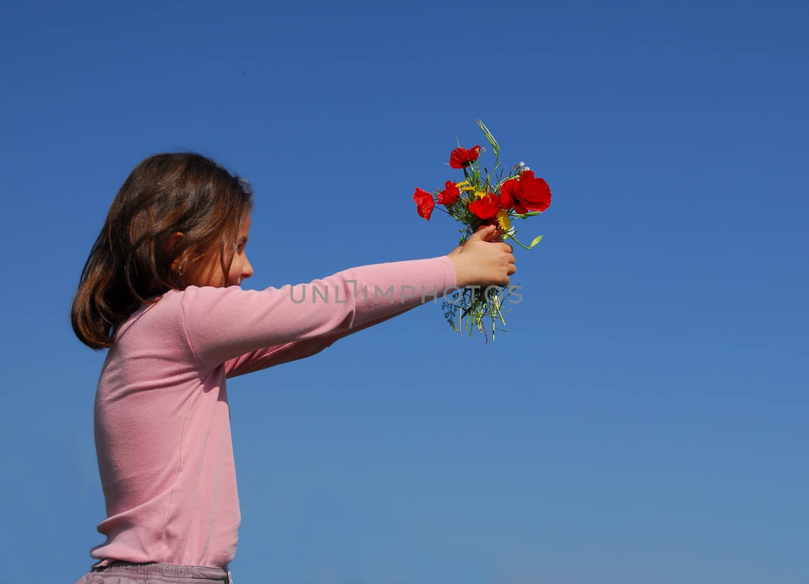 a little girl give flowers on a blue sky