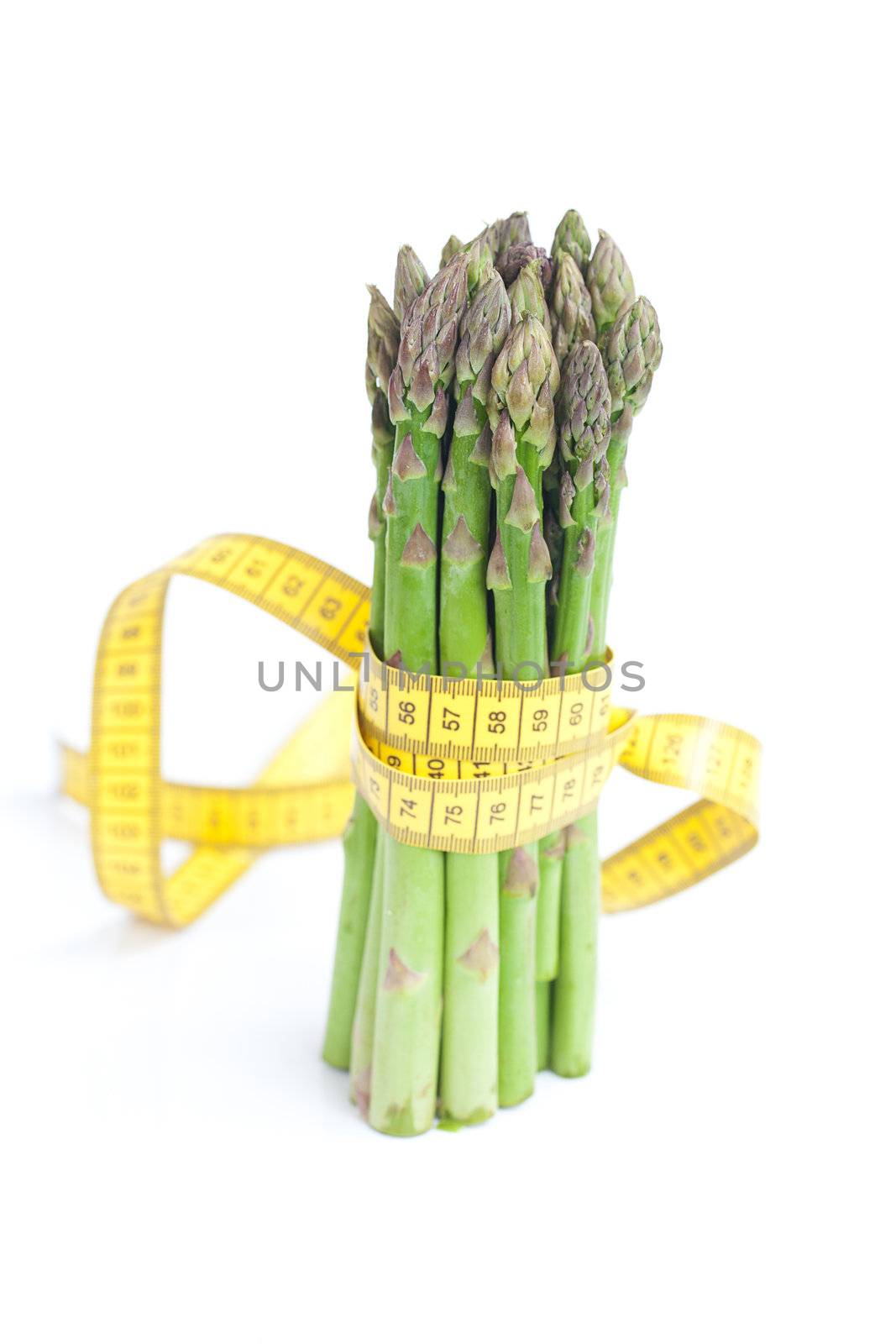 bunch of asparagus tied with measuring tape isolated on white by jannyjus