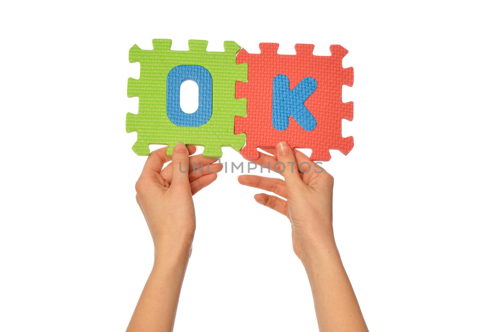 teacher holding in the hand the amusing colored educational puzzles with the word ok