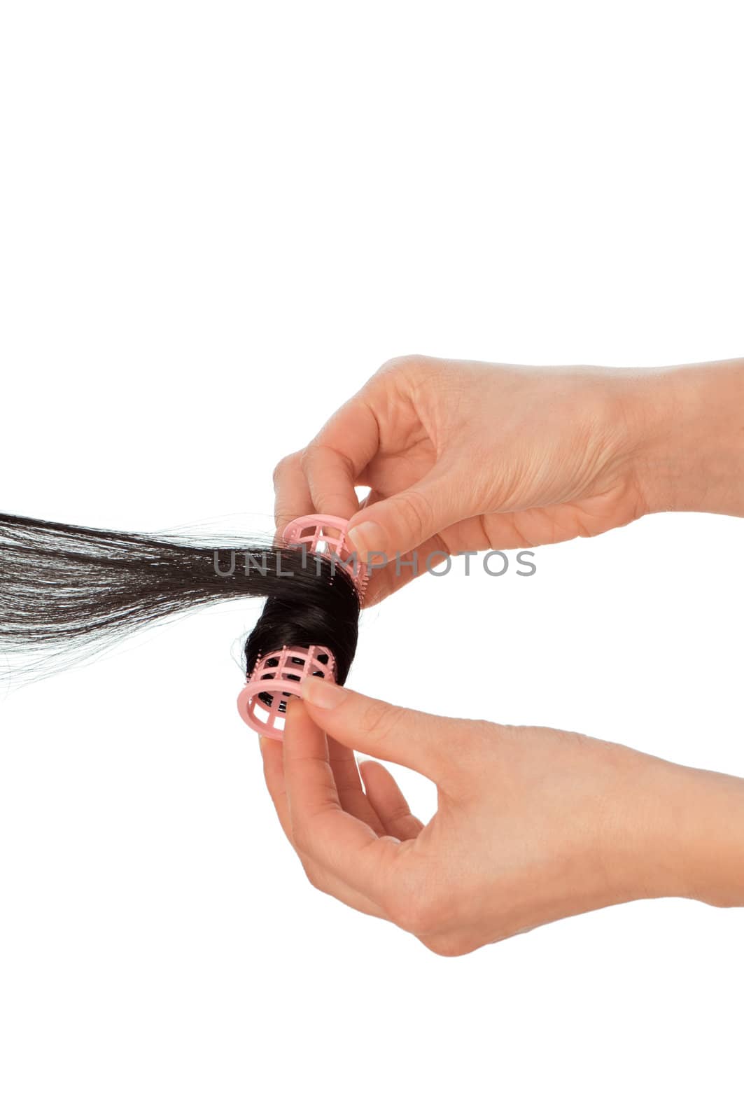 hairdresser makes curls on the woman's black hair