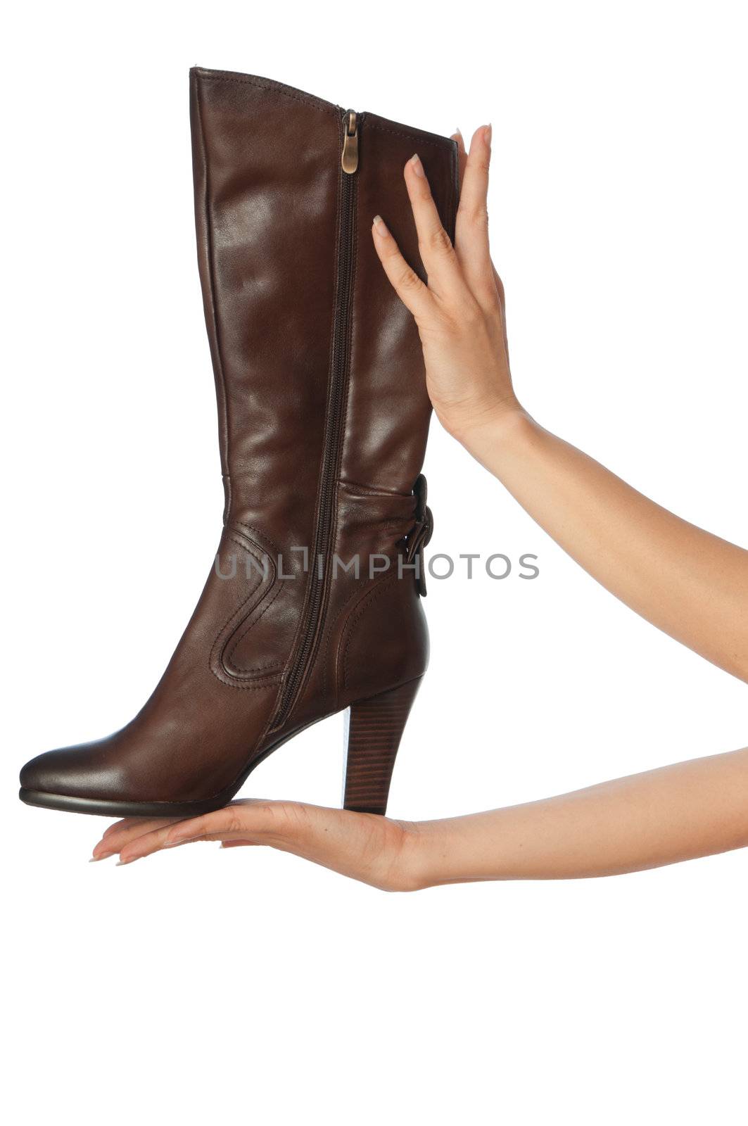 brown female boots in hands at the saleswoman