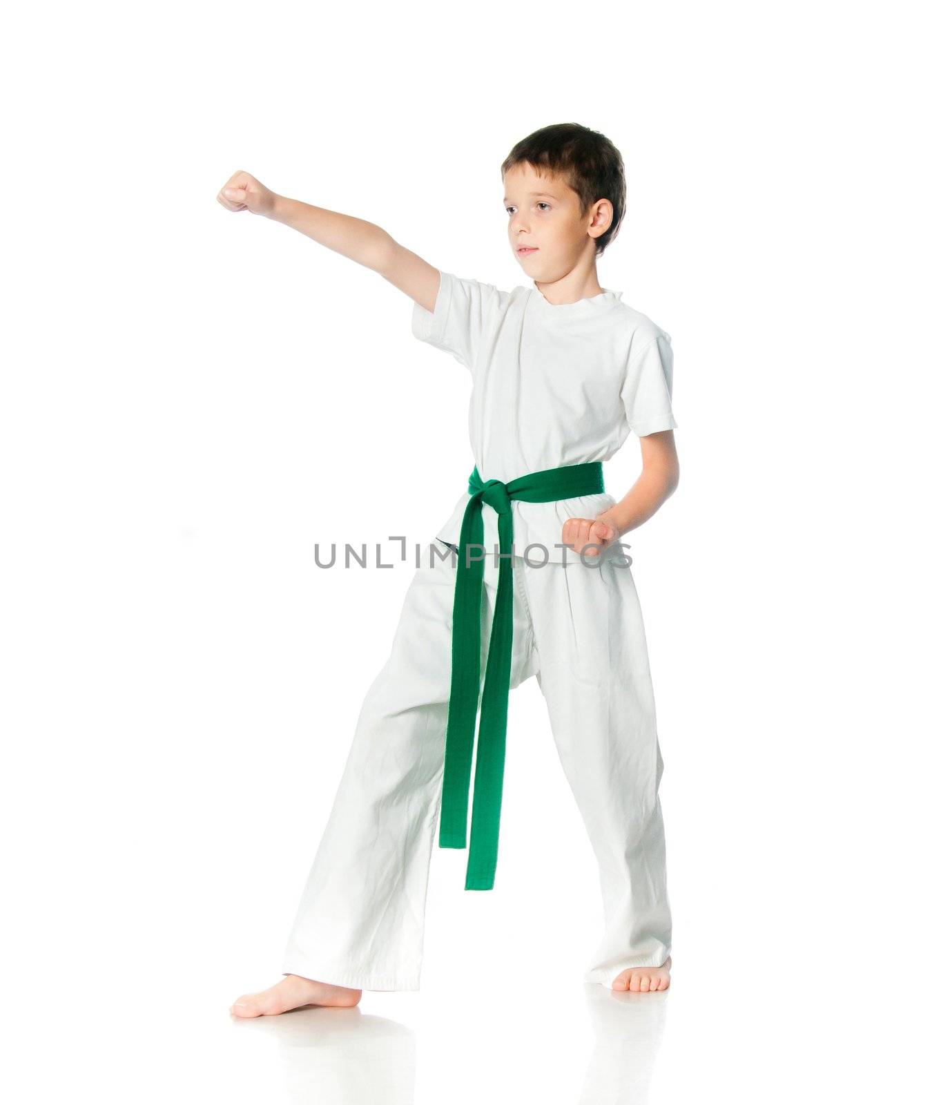 Young boy in kimono with green belt practising  on a white background