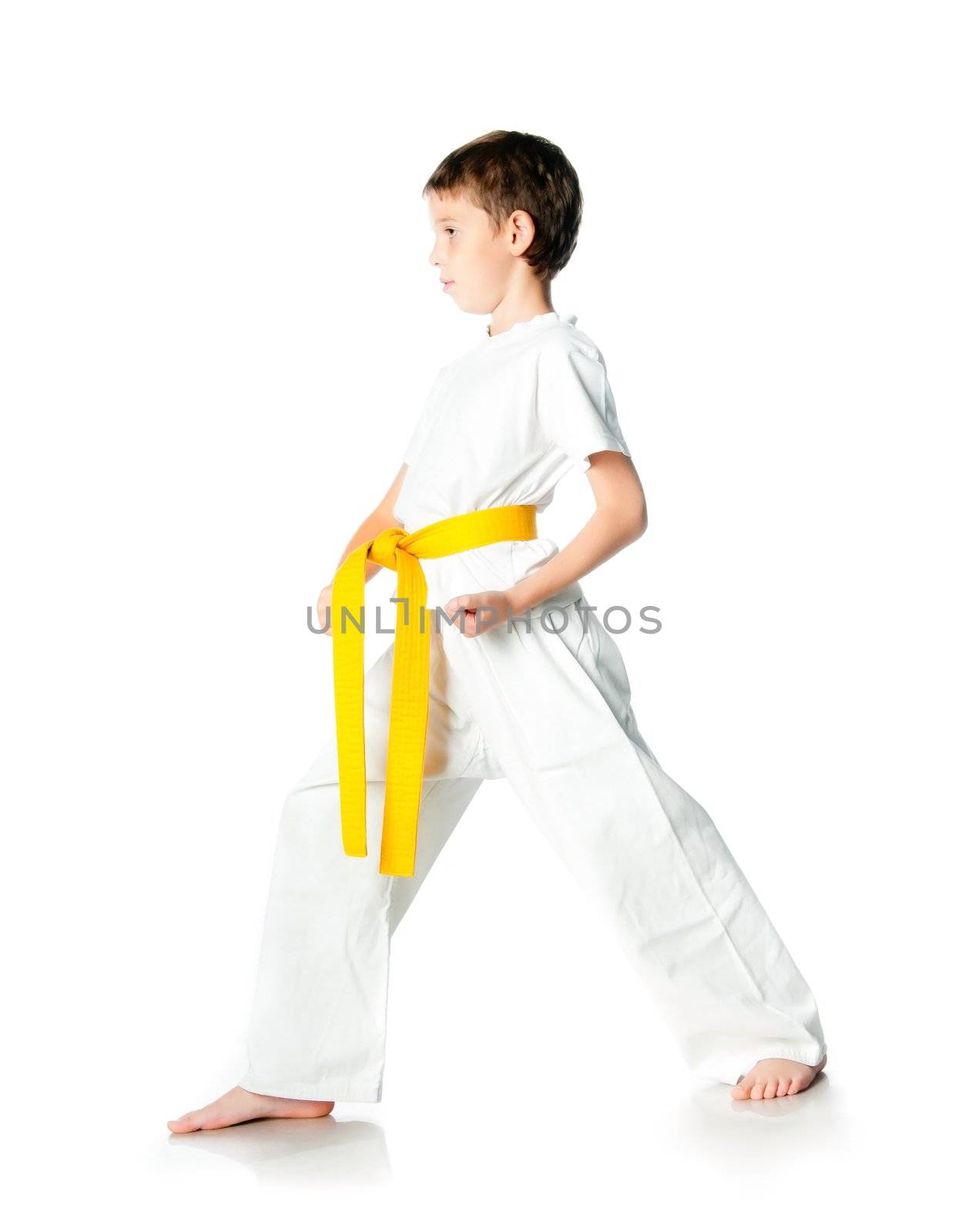 Young boy in kimono with yellow belt  on a white background