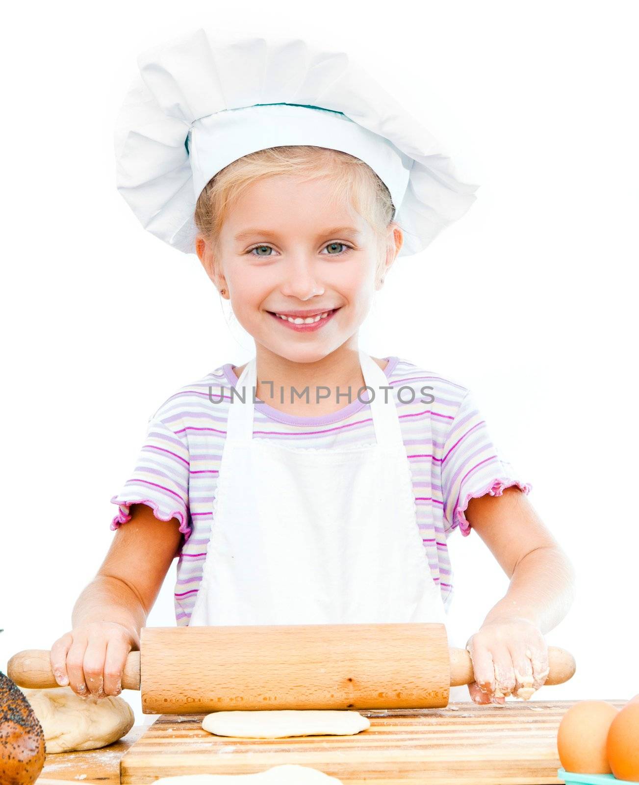 Little girl makes dough with rolling pin on a white background