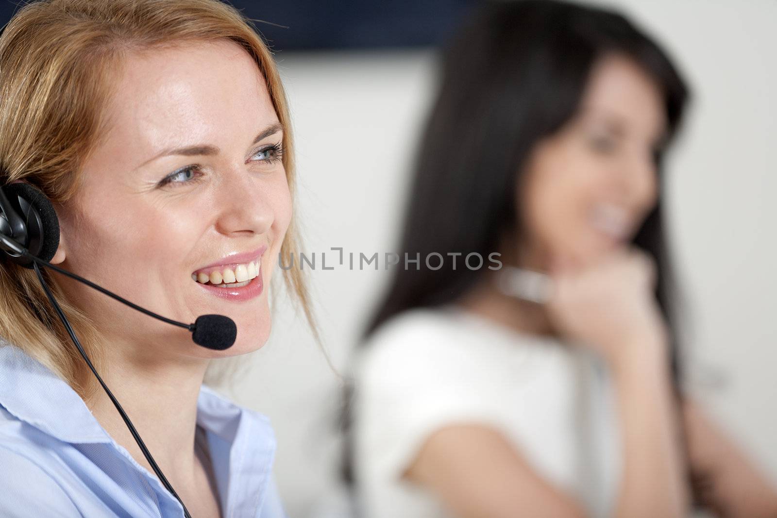 Two colleagues working in a busy call centre office.