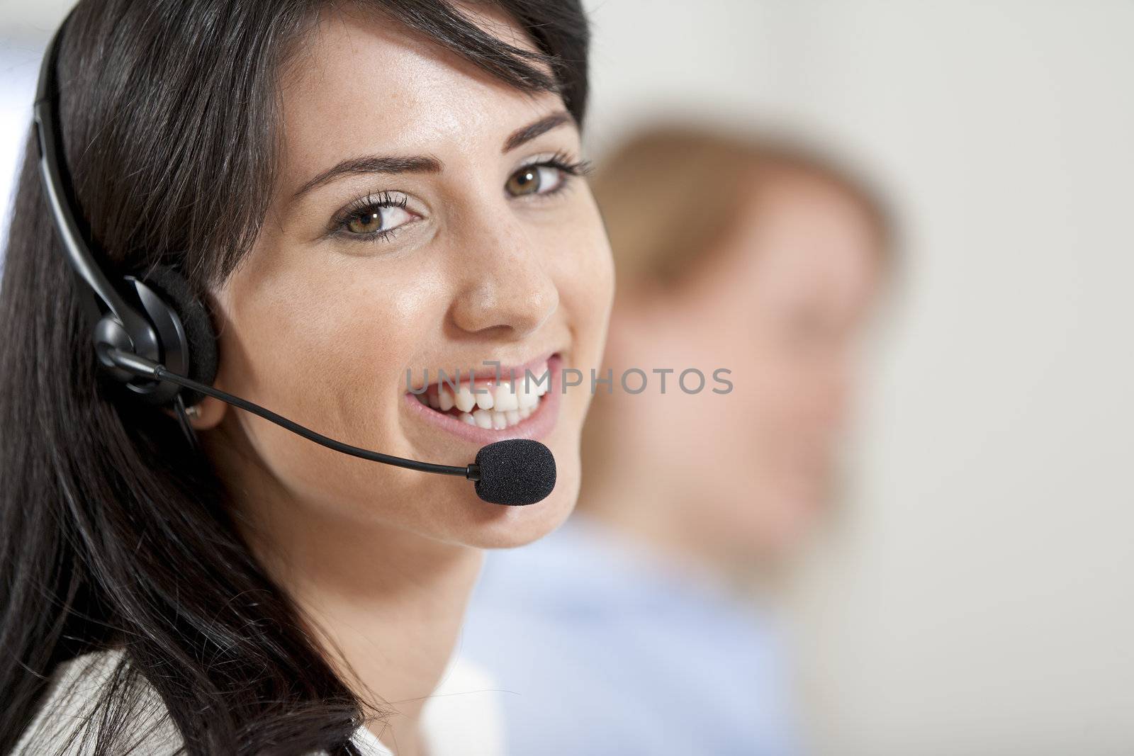 Two colleagues working in a busy call centre office.