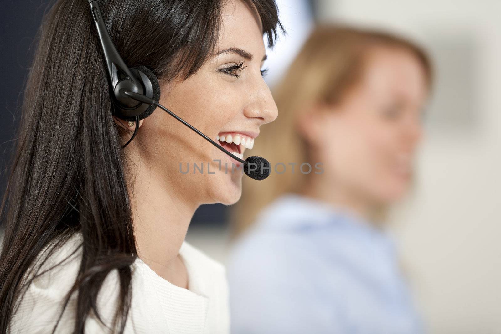 Two colleagues working in a busy call centre office.