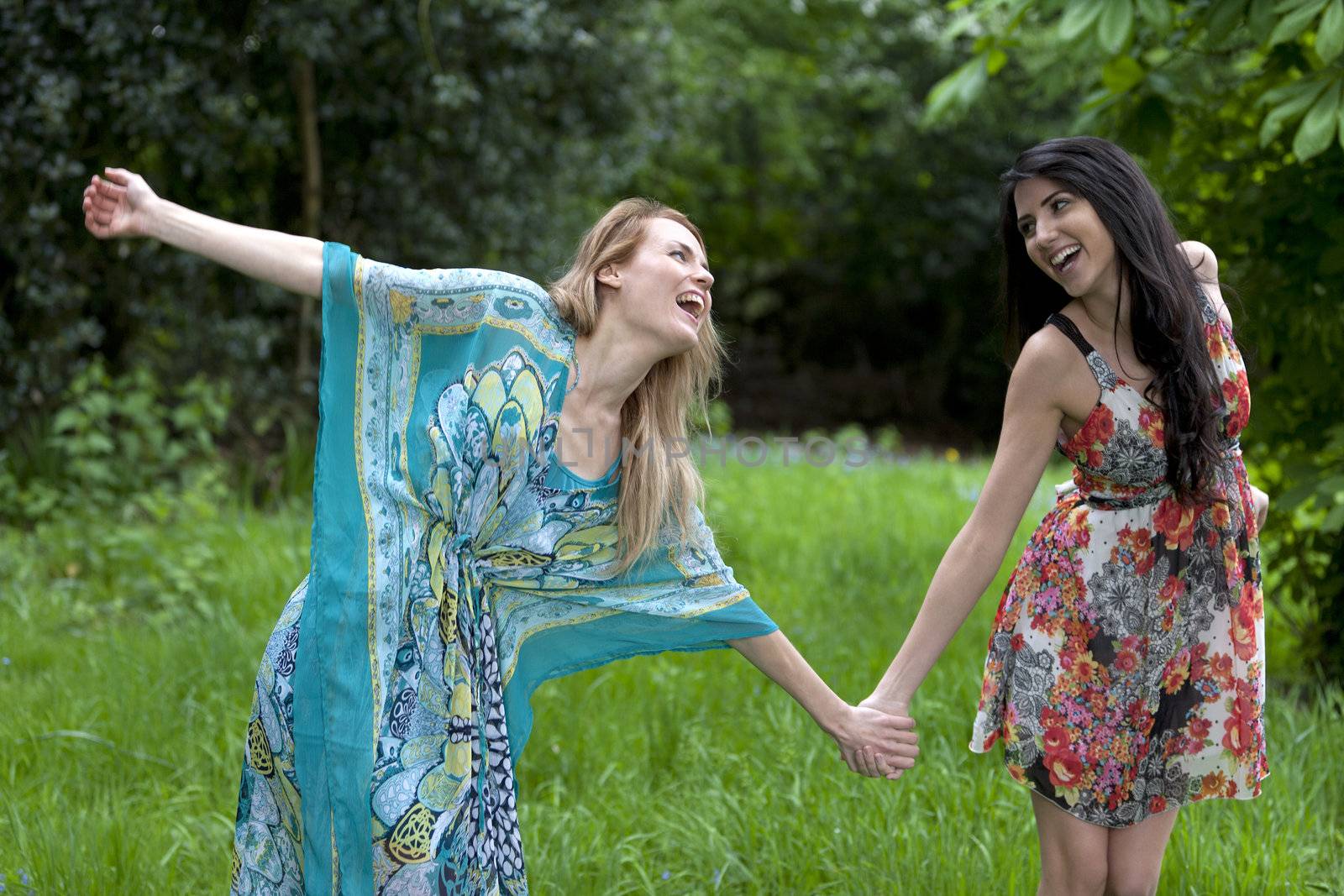 Two friends messing around in a field in summer time