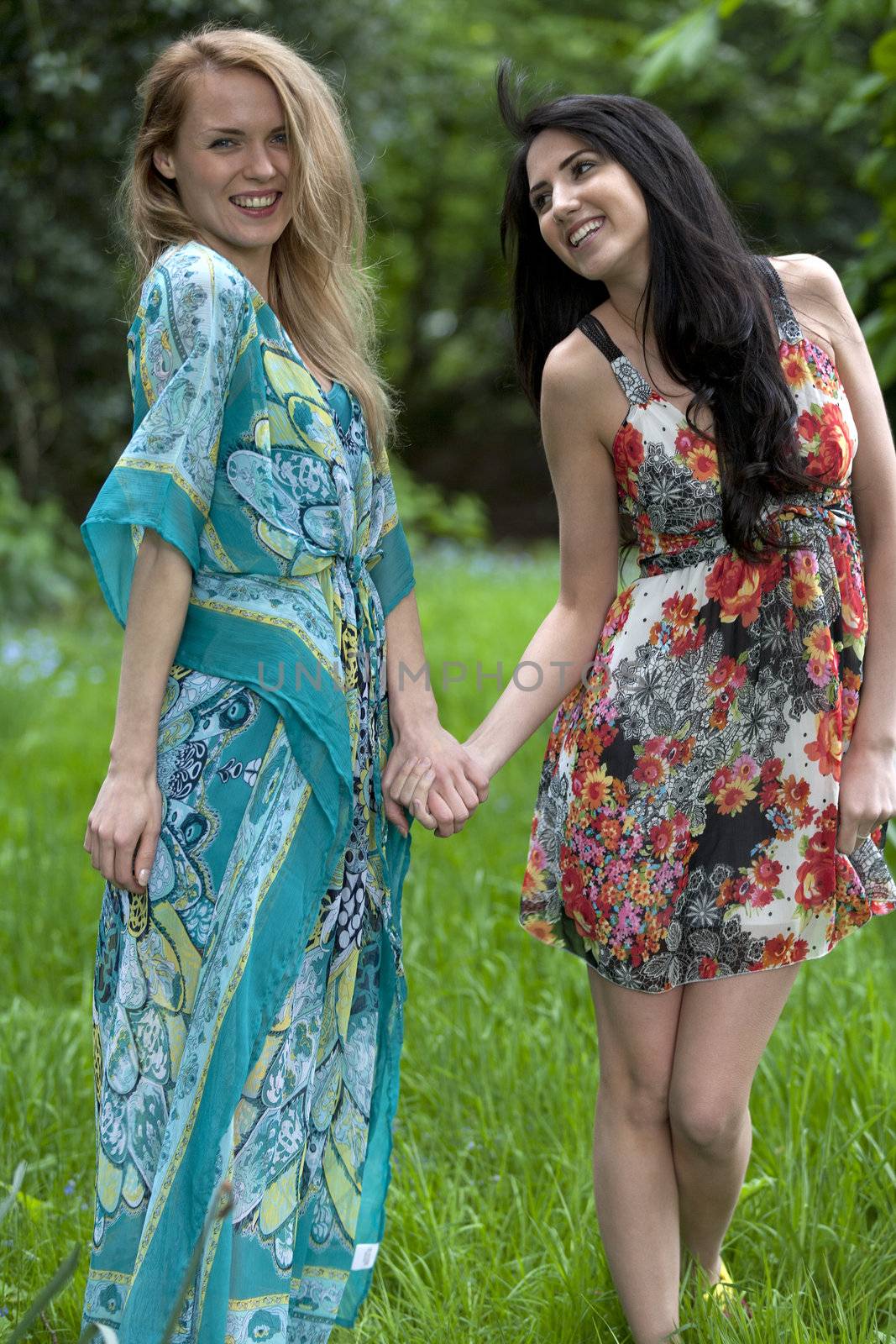 Two friends messing around in a field in summer time