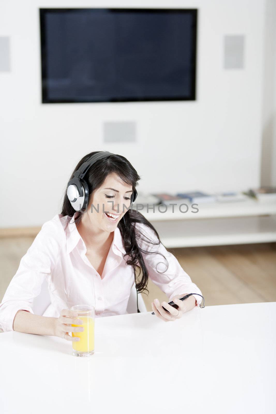 Young woman listening to music with headphones at home.