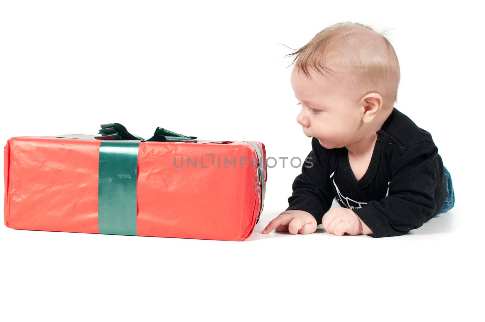 Beautiful baby boy watching on christmas present on white